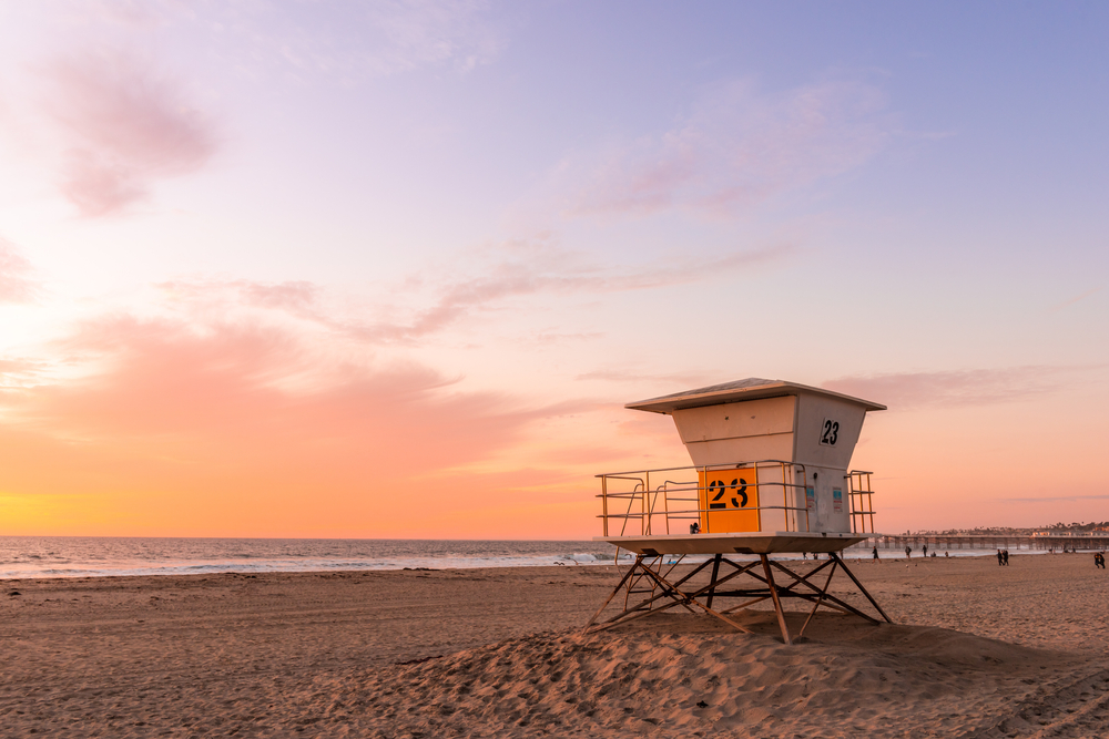 View of lifeguard tower on California beach at sunset.