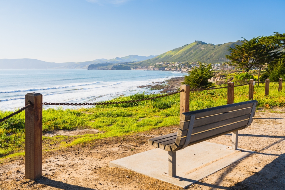 View of a bench overlooking a California beach.