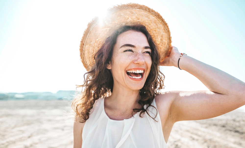 Woman smiles on the beach.